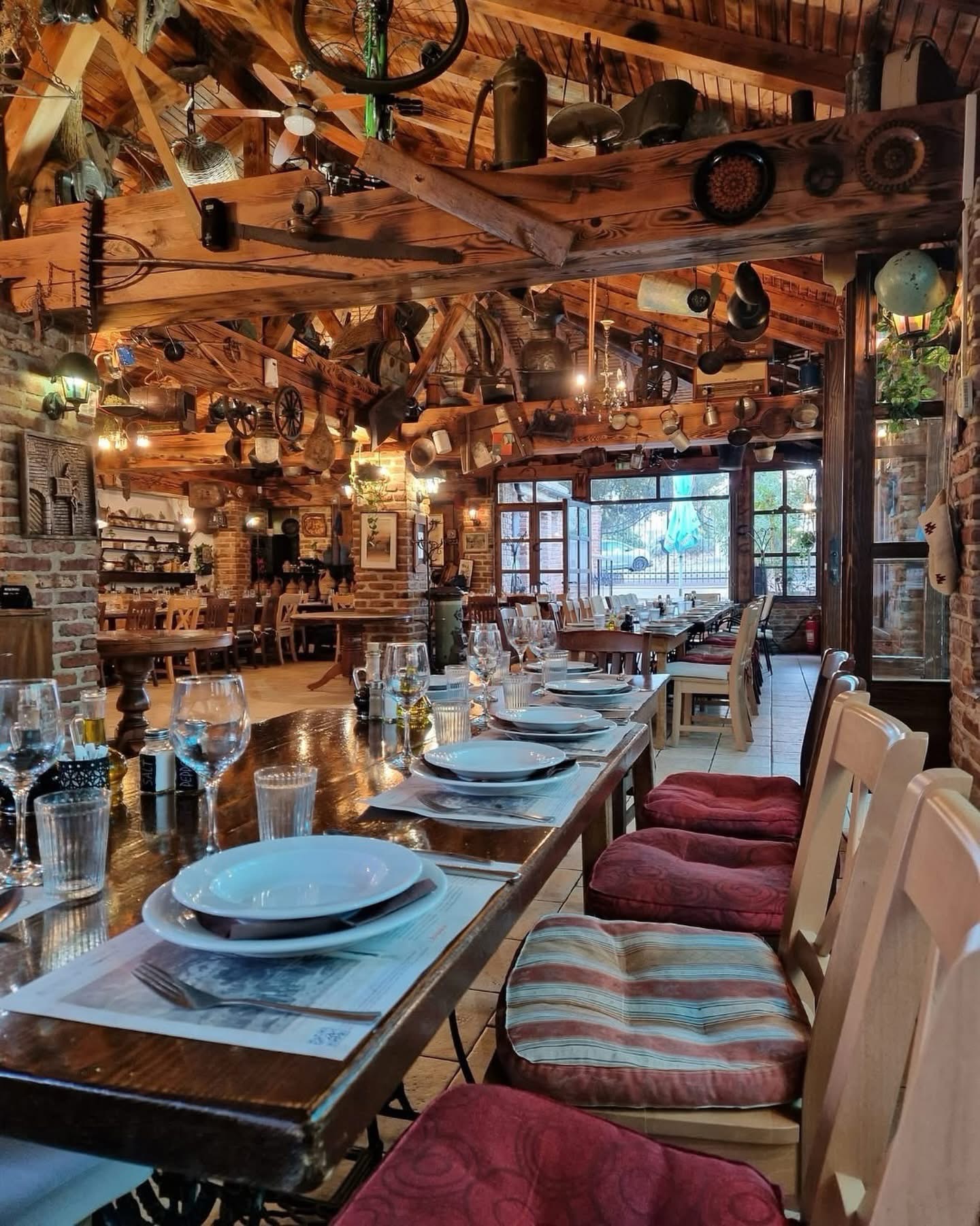 Rustic interior with beamed ceiling hung with antique tools