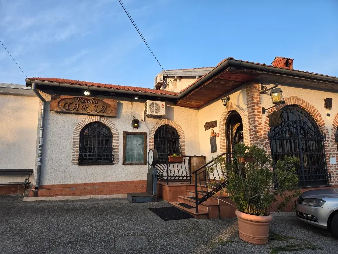 Exterior of Konoba Tarsa at dusk with the illuminated Konoba TARSA sign and arched windows